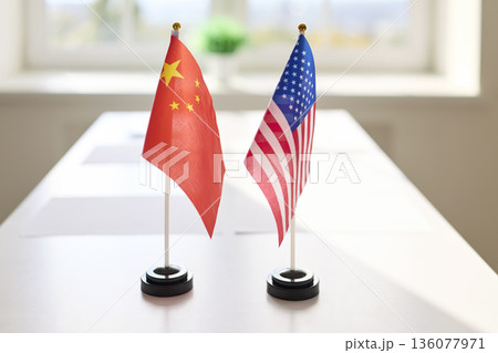 Miniature China and USA flags on conference table, symbolizing negotiation Miniature China and USA flags on conference table, symbolizing negotiation 136077971
