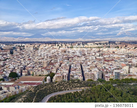 Sunshine illuminating urban rooftops, Scenic aerial view of city with mountains and coastal haze Sunshine illuminating urban rooftops, Scenic aerial view of city with mountains and coastal haze 136078011