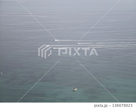 Vessels glide smoothly, Multiple ships move harmoniously across shimmering sea with white foam tails 136078023