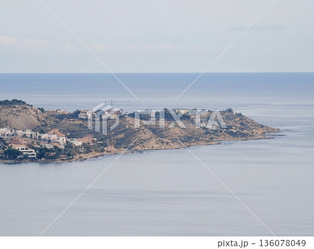 Peaceful coastal area for relaxation, Calm promontory featuring scattered houses and tranquil ocean views 136078049