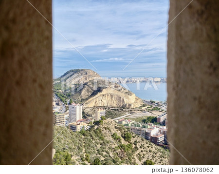 Coastal cliff with harbor background, Rugged cliffs surround calm sea and scattered coastal structures 136078062