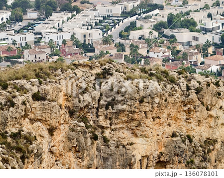 Rough geological structure contrasted vividly with structured neighborhood and distant cityscape Rough geological structure contrasted vividly with structured neighborhood and distant cityscape 136078101
