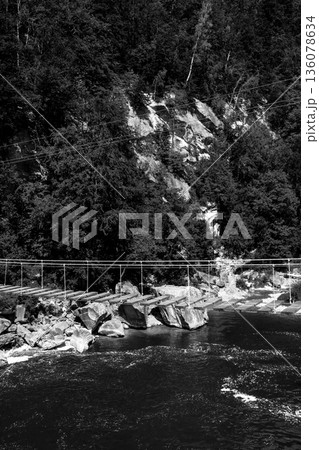 Abandoned Bridge Over Wild River in Mountains, Black and White Abandoned Bridge Over Wild River in Mountains, Black and White 136078634