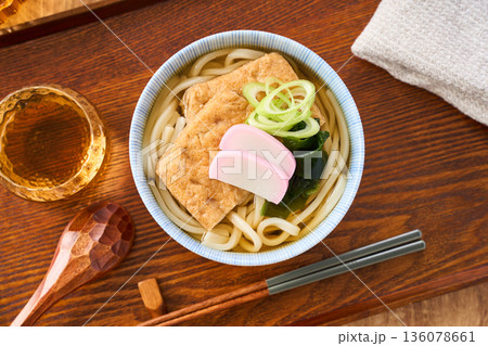 大きな油揚げにかまぼこを添えたきつねうどん 136078661
