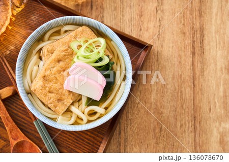 大きな油揚げにかまぼこを添えたきつねうどん 136078670