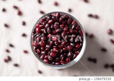 Azuki beans, Adzuki bean or red mung beans in glass on white fabric background Azuki beans, Adzuki bean or red mung beans in glass on white fabric background 136079150
