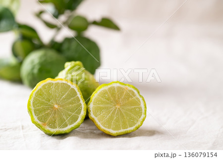 Kaffir lime fruit with leaf on white fabric background, Thai food ingredient Kaffir lime fruit with leaf on white fabric background, Thai food ingredient 136079154