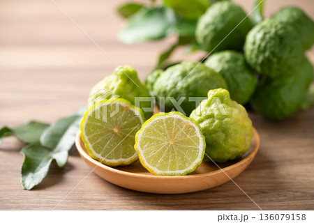 Kaffir lime fruit with leaf on wooden background, Thai food ingredient 136079158