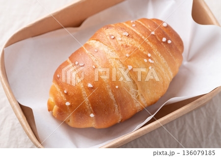 Top view of Salt bread (Shio pan) with sea salt flakes in paper food box, Japanese bakery style Top view of Salt bread (Shio pan) with sea salt flakes in paper food box, Japanese bakery style 136079185