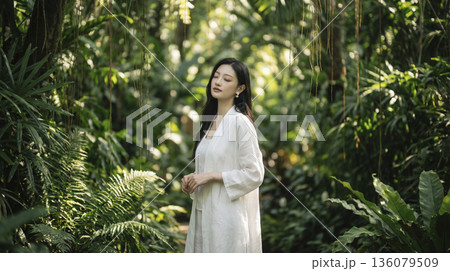 緑豊かな森の中で白い服を着て目を閉じ深呼吸する日本人女性 136079509