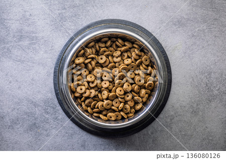 Dry pet food. Dry kibble food on gray table. Top view. Dry pet food. Dry kibble food on gray table. Top view. 136080126