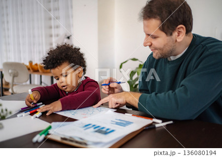 Father and son drawing together at home Father and son drawing together at home 136080194