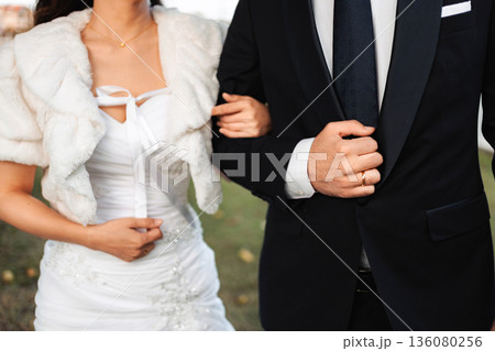 Interracial wedding couple walking together on special day Interracial wedding couple walking together on special day 136080256
