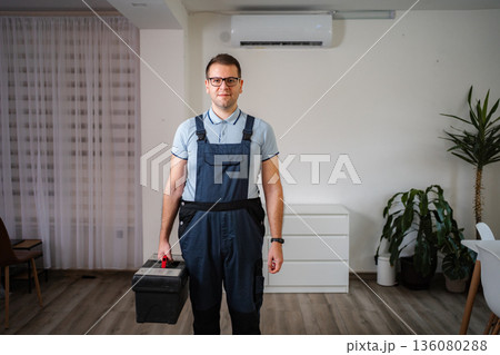 HVAC technician carrying toolbox for air conditioner maintenance HVAC technician carrying toolbox for air conditioner maintenance 136080288