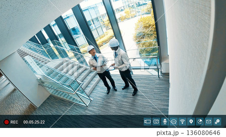 ビル屋内で会話するエンジニアを映した監視カメラ映像 136080646