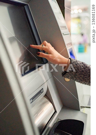 Woman using ATM touchscreen for banking transaction Woman using ATM touchscreen for banking transaction 136081169
