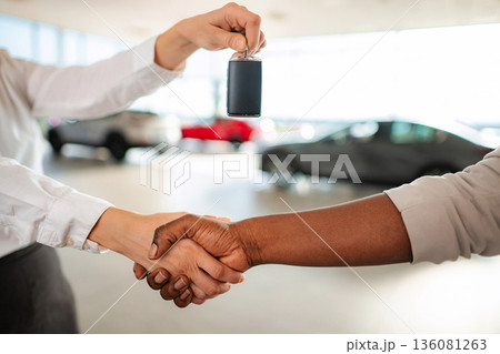 People shaking hands and receiving car key after car purchase People shaking hands and receiving car key after car purchase 136081263