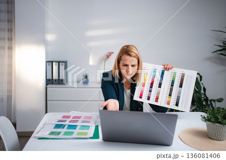 Woman presenting color palette during video call at home office 136081406
