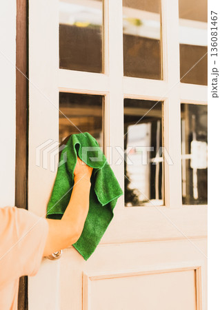 Hosue maid cleaning glass door window at home. Hosue maid cleaning glass door window at home. 136081467