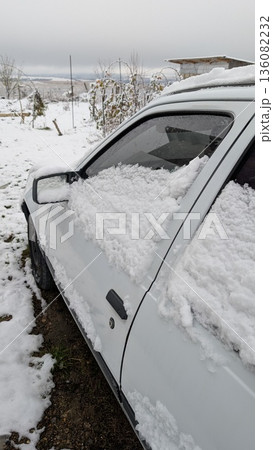 Quiet winter landscape featuring dusted vehicle and distant barn 136082232