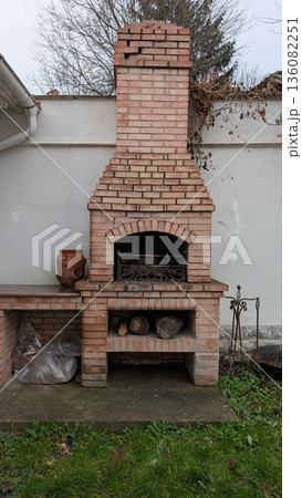 Traditional brick barbecue with clay pots and firewood arrangement Traditional brick barbecue with clay pots and firewood arrangement 136082251
