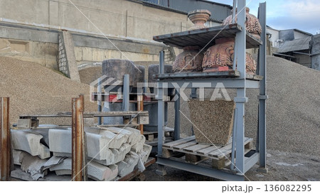 Industrial shelving surrounds loose aggregate and stone arrangements 136082295