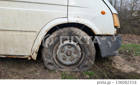 Commercial delivery vehicle halted due to front wheel deflation and mud 136082318
