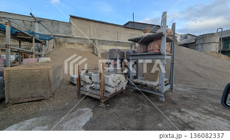 Materials for base construction placed amid muddy and factory setting Materials for base construction placed amid muddy and factory setting 136082337