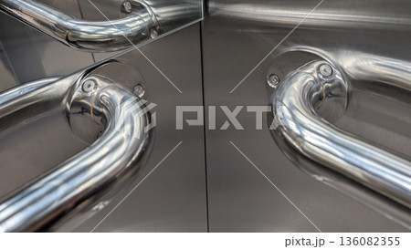 Shimmering metallic elevator pull handles with mirrorlike reflections Shimmering metallic elevator pull handles with mirrorlike reflections 136082355