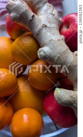 Brightly colored fruits with spicy ginger in ceramic bowl 136082363