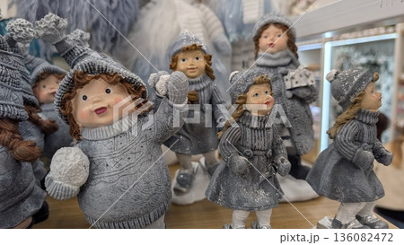 Vibrant Knitted Figures With Facial Artwork Showcased In Reflective Surroundings Within Retail Environment 136082472