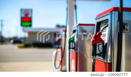Row of classic vintage red gas pumps with analog meters at sunny day for retro transportation and americana road trip nostalgia concept history Row of classic vintage red gas pumps with analog meters at sunny day for retro transportation and americana road trip nostalgia concept history 136082777