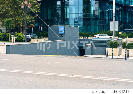 Parking entrance located near a modern building in a busy city area in the afternoon Parking entrance located near a modern building in a busy city area in the afternoon 136083238