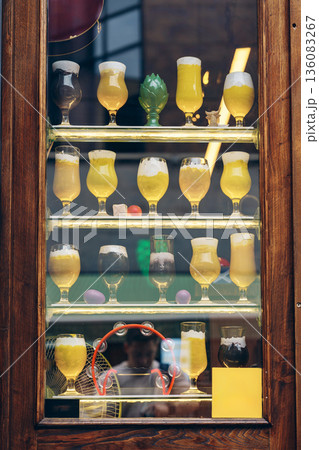 Variety of drinks displayed in glasses at a bar in a city setting during the day Variety of drinks displayed in glasses at a bar in a city setting during the day 136083267