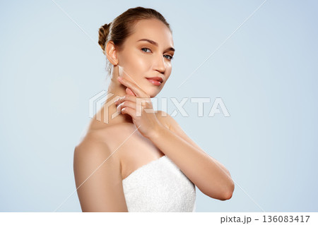 Woman posing with hand on chin in studio setting during daylight Woman posing with hand on chin in studio setting during daylight 136083417