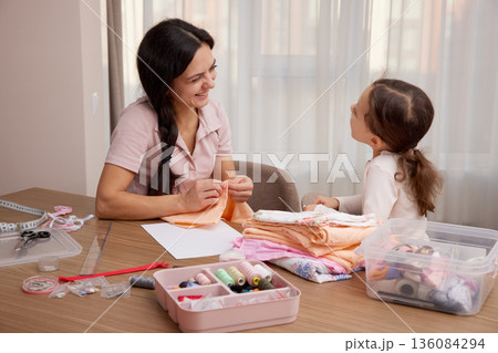 Mother and child daughter bonding, learning craft skills, and creating handmade items 136084294