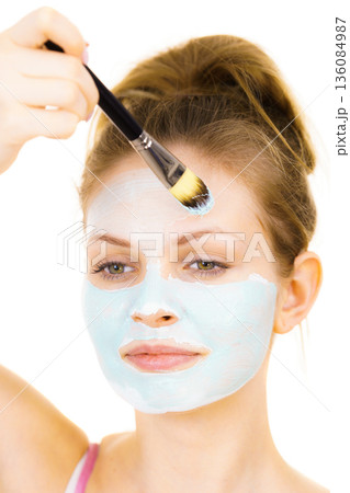 Girl apply green mud mask to face 136084987