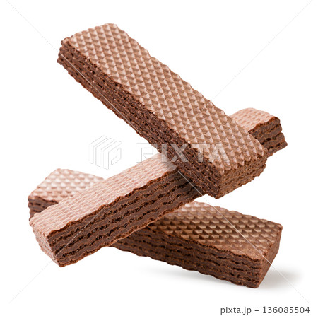 Chocolate wafers falling on a white background. Isolated 136085504