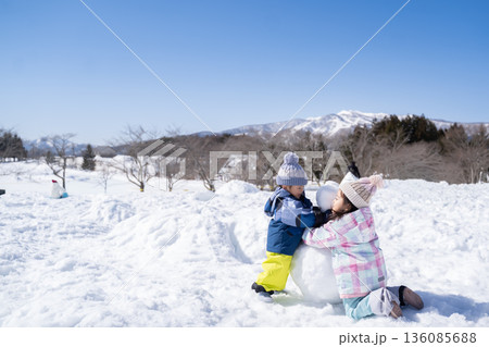 雪だるまを作って雪遊びする子供たち 136085688