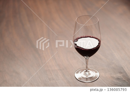Red wine in wineglass on black walnut table with copy space Red wine in wineglass on black walnut table with copy space 136085793