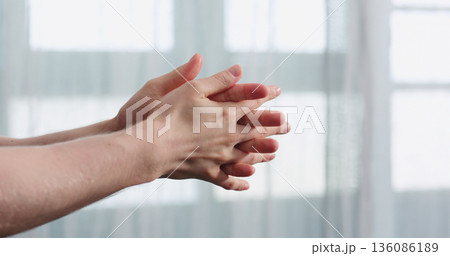 man apply liquid sanitizer on his hands standing in front of the window closeup man apply liquid sanitizer on his hands standing in front of the window closeup 136086189