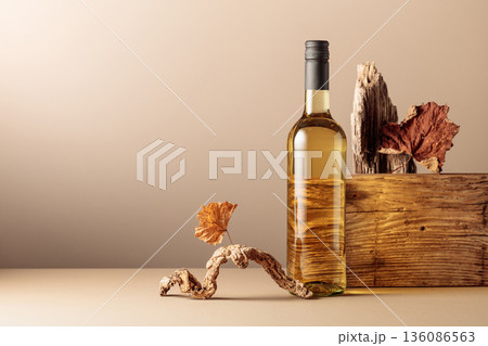 Bottle of white wine with a composition of old plank, dry snags, and dried vine leaves. Bottle of white wine with a composition of old plank, dry snags, and dried vine leaves. 136086563