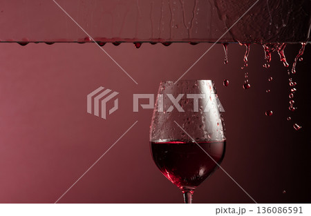 Red wine flows down into a glass. Red wine flows down into a glass. 136086591