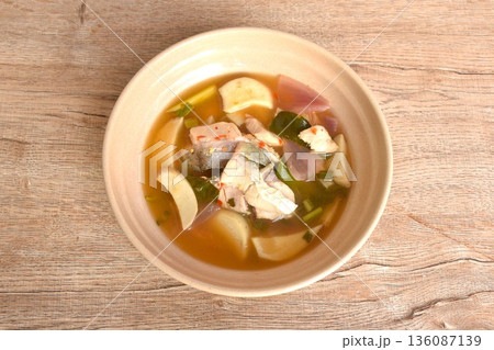 boiled bass fish meat and mushroom in clear tom yum Thai herb soup on plate 136087139
