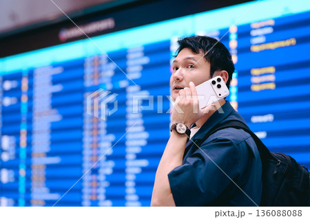 空港で電話する男性 ■撮影協力：関西国際空港（KIX） 136088088