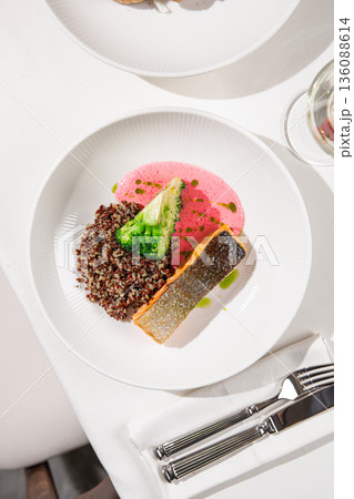 Grilled salmon with quinoa broccoli and sauce 136088614