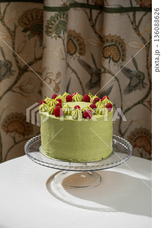 Pistachio raspberry cake on glass stand 136088626
