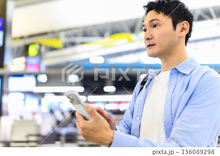 空港でスマホ操作する男性 ■撮影協力:関西国際空港(KIX) 空港でスマホ操作する男性 ■撮影協力:関西国際空港(KIX) 136089298