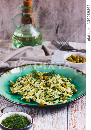 Green salad with cabbage, peas and dill on a plate on the table vertical view Green salad with cabbage, peas and dill on a plate on the table vertical view 136089862