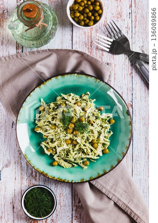 Vegetarian salad with cabbage, green peas and herbs on a plate on the table top and vertical view 136089866